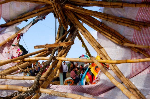 Looking through the wreckage at a family sitting on a grave