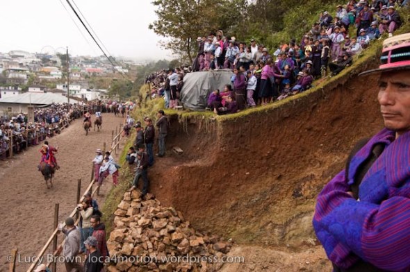 Spectators watching the race. The man in purple is wearing the traditional costume from another village. Skach Koyl horse race, Todos Santos Cuchumatán, Huehuetenango, Guatemala