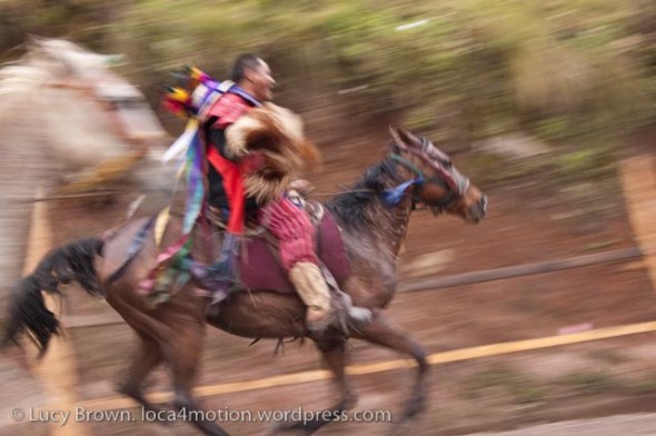 Jockey carrying a chicken on the final lap of his last year racing. Skach Koyl horse race, Todos Santos Cuchumatán, Huehuetenango, Guatemala