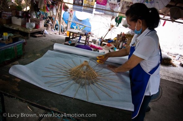 Cutting sa paper to size around a parasol frame, traditional Thai parasols, Chiang Mai, Thailand