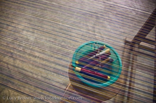 Spindles of Thai silk thread seen through threads on loom, Chiang Mai, Thailand